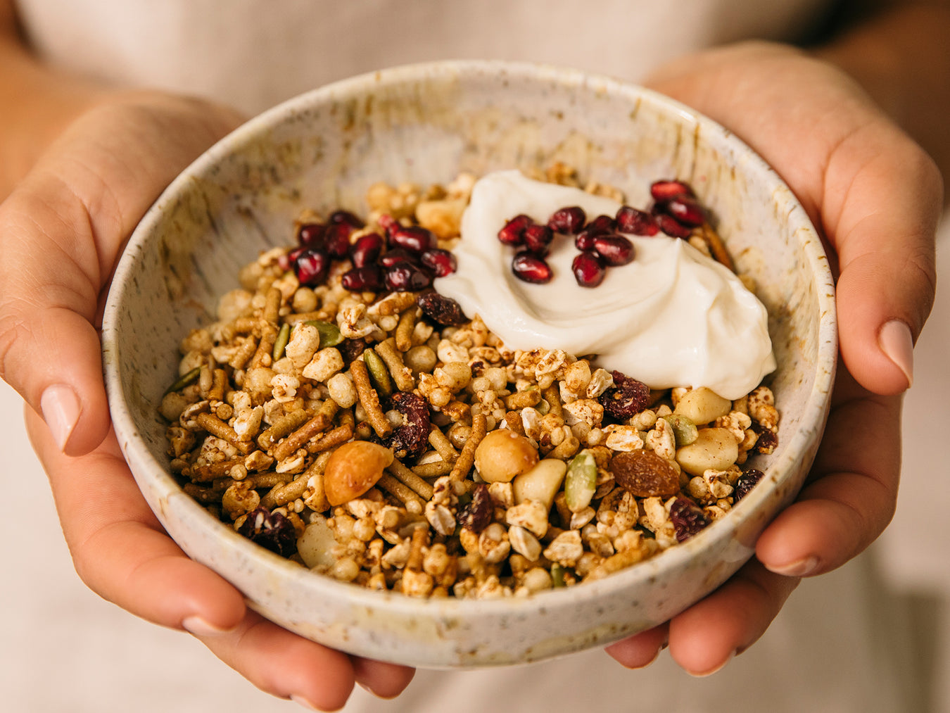 Woman holding ceramic bowl with Brookfarm gluten free muesli in the bowl