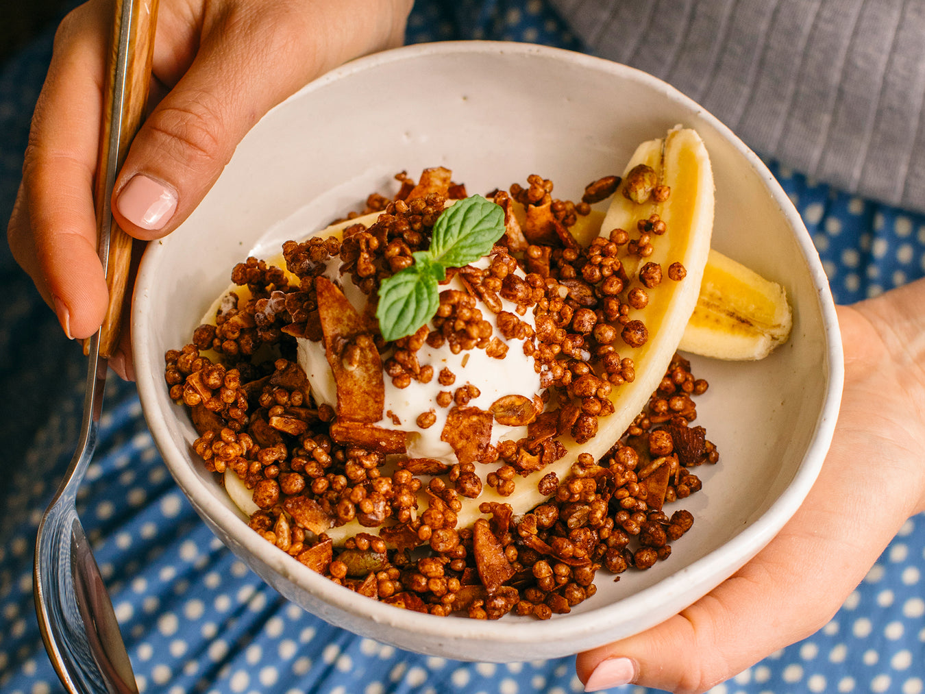 Brookfarm Granola with mint, yoghurt and banana in a ceramic bowl with woman in background