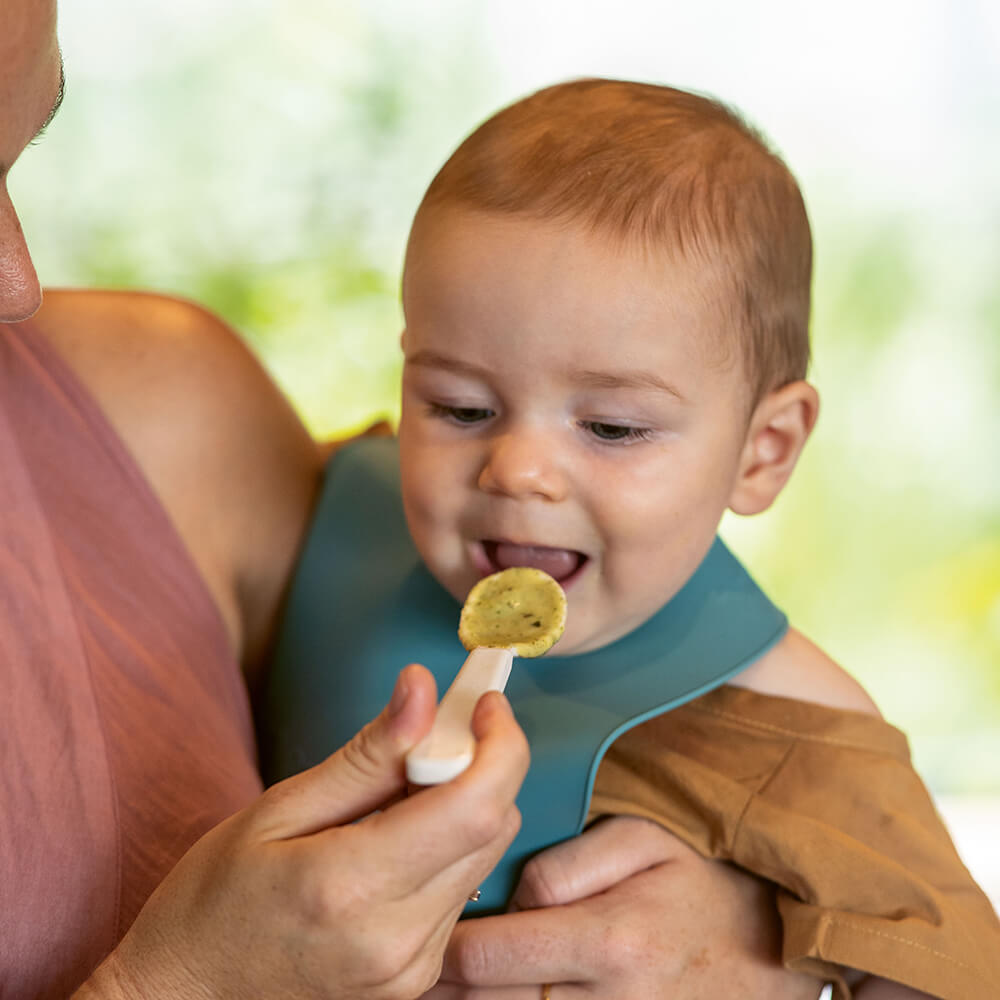 Mother spoon feeding baby